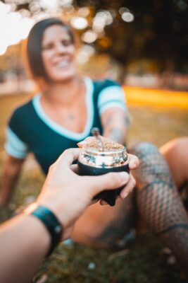 woman smiling and taking a mate gourd with yerba mate
